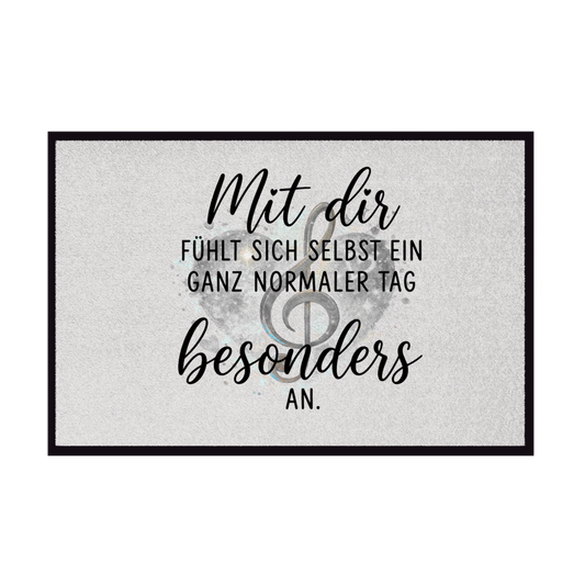 Rutschfeste graue Fußmatte mit Gummirand, Herz-Motiv, Notenschlüssel und dem Spruch "Mit dir fühlt sich selbst ein ganz normaler Tag besonders an