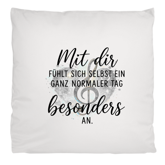 Flauschiges weißes Kopfkissen mit Herz-Motiv, Notenschlüssel und dem Spruch "Mit dir fühlt sich selbst ein ganz normaler Tag besonders an"