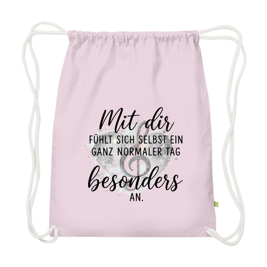 Pinkener Premium Bio-Turnbeutel aus schwerer Baumwolle mit Herz-Motiv, Notenschlüssel und dem Spruch "Mit dir fühlt sich selbst ein ganz normaler Tag besonders an"
